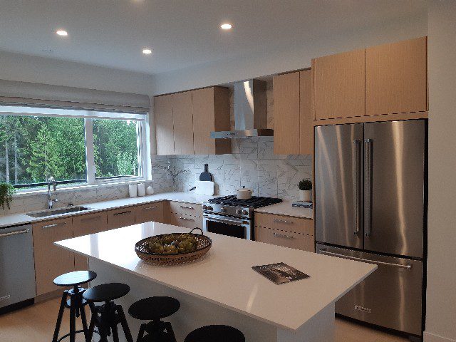 a kitchen with a white island and a stainless steel refrigerator